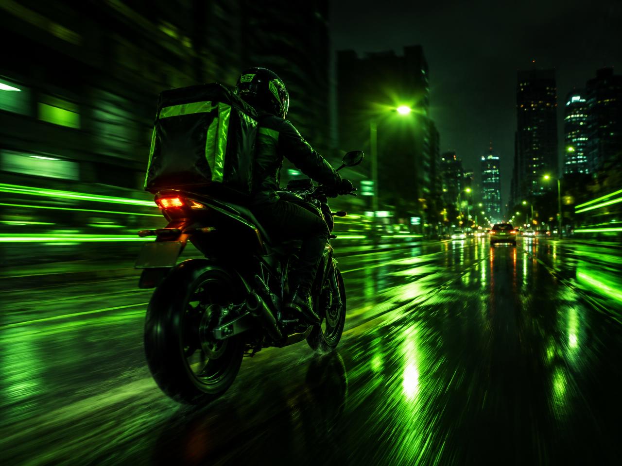 Motoboy pilotando à noite na cidade com luzes verdes